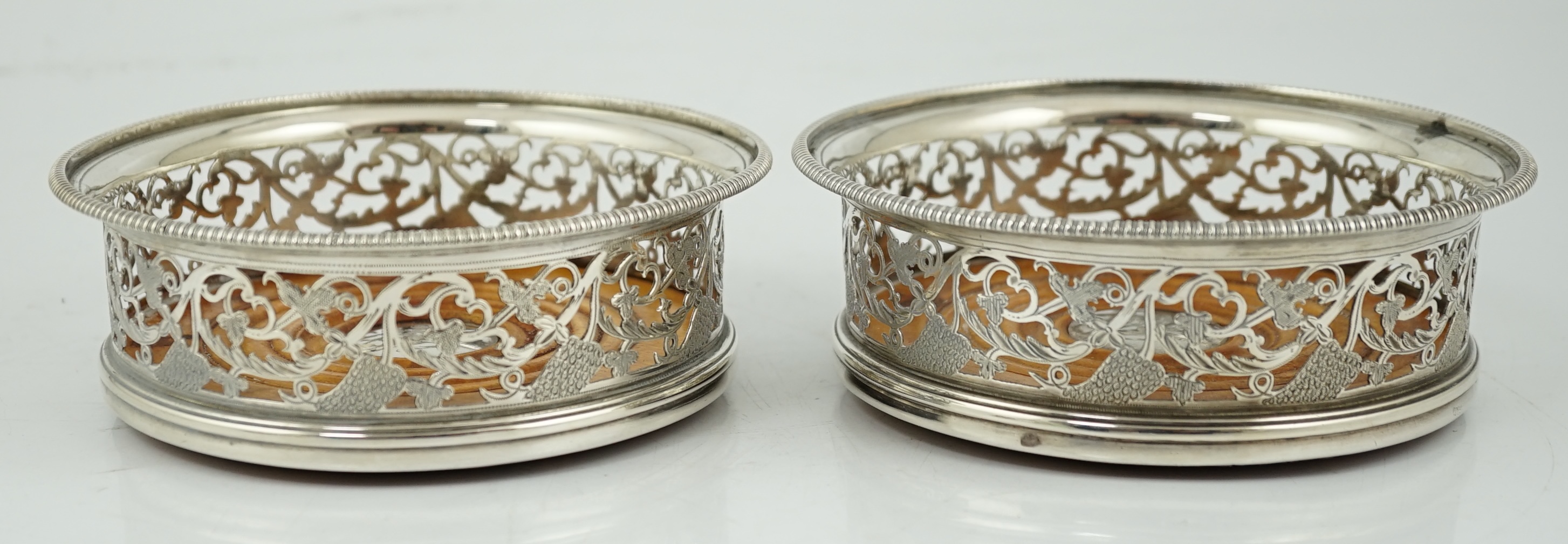 A pair of George III pierced silver mounted wine coasters, William Allen III